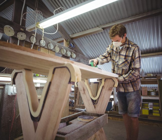 Man using modified planer in the surfboard workshop