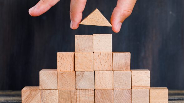 Marketing concept on wooden and dark background side view. hand arranging wooden block as stacking.